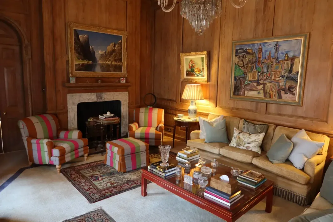Reupholstered armchairs and sofa in a traditional wood-panelled living room